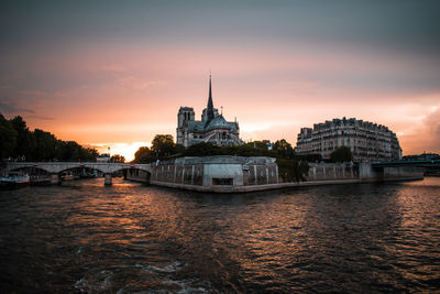 View of buildings at waterfront during sunset