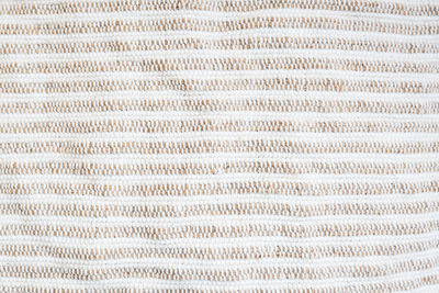 Beige-white striped background, rough fabric, close-up. selective focus