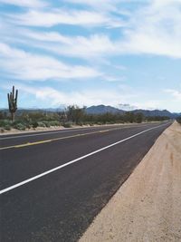 View of empty road against cloudy sky