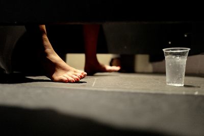 Low section of woman on floor during sunny day