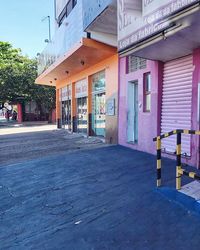 Empty street amidst houses against buildings in city