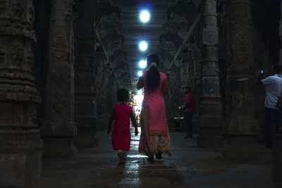 Rear view of people walking in temple