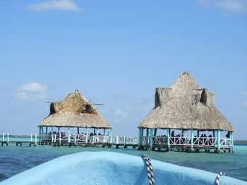 Built structure by sea against blue sky