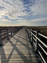 Wooden boardwalk against sky