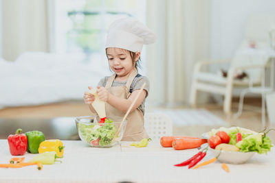 Midsection of woman with vegetables on table
