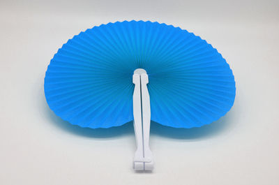 Close-up of hand fan against white background