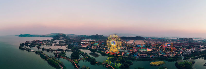 High angle view of bay and cityscape against sky during sunset