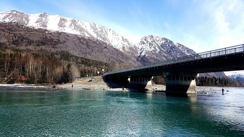 Bridge over river against sky during winter