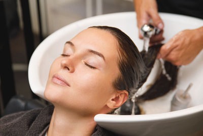 Close-up of woman washing hands in sink