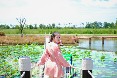 Woman standing by plants against sky