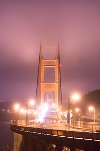 Low angle view of illuminated bridge against sky at night