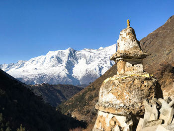 Panoramic view of cross on mountain against clear sky