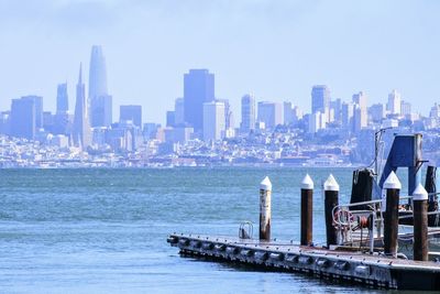 Sea by buildings against sky in city