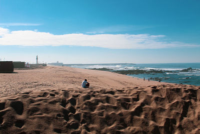 Rear view of man on beach against sky