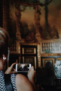 Midsection of woman photographing through smart phone