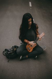 Full length of woman sitting on wall