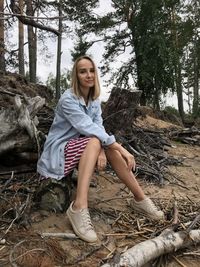 Portrait of smiling young woman sitting on land