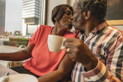 Senior couple kissing each other at cafe