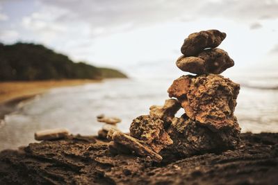 Close-up of rocks on beach against sky