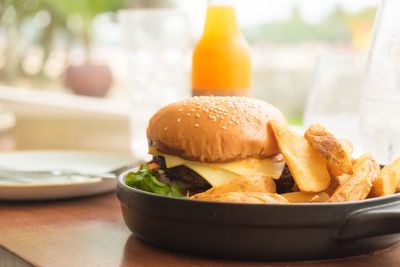 Close-up of burger with prepared potatoes in container