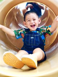 Portrait of cute baby boy sitting in kitchen