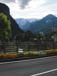 Scenic view of road by mountains against sky