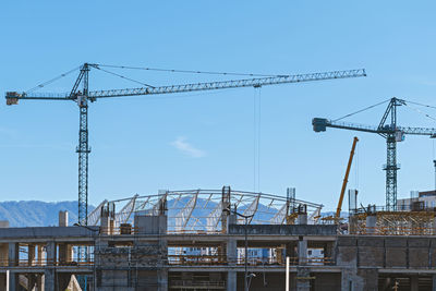 Construction site of the stadium with tower cranes at blue sky background. batumi, georgia