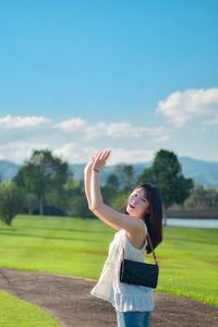 Rear view of woman standing on field against sky