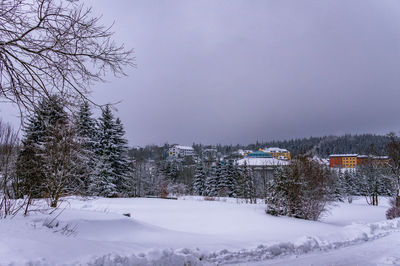 Snow covered field against sky during winter