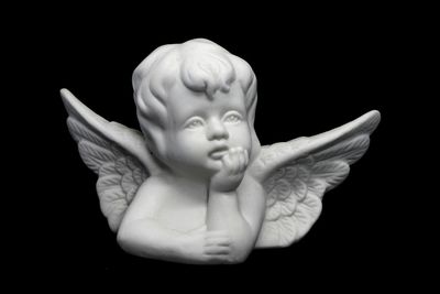 Close-up of angel sculpture against black background