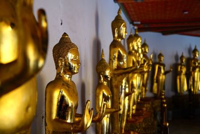 Close-up of buddha statues against wall