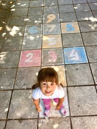 High angle portrait of girl playing hopscotch