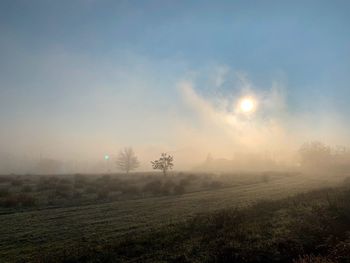 Scenic view of field against sky during foggy weather