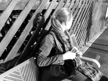 Woman sitting on bench in city