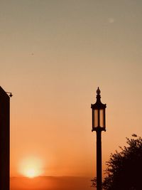 Low angle view of street light against orange sky