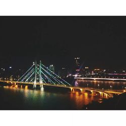 Suspension bridge over river at night