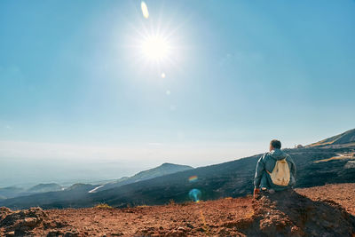 Mature man enjoying freedom, while admiring panoramic view of colorful summits of volcano etna