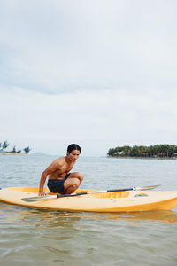 Man swimming in sea against sky