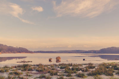 Scenic view of lake against cloudy sky