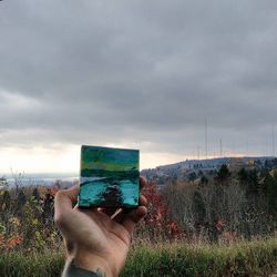 Scenic view of grassy field against cloudy sky