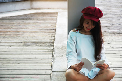 Woman reading book while sitting outdoors