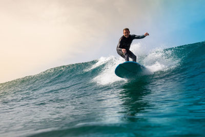 Man surfing on sea against sky