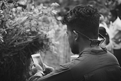 Rear view of man using mobile phone