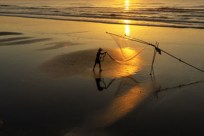 Fisherman working with net at beach