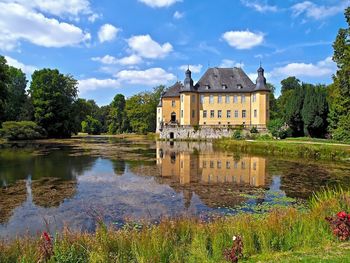 Building by lake against sky