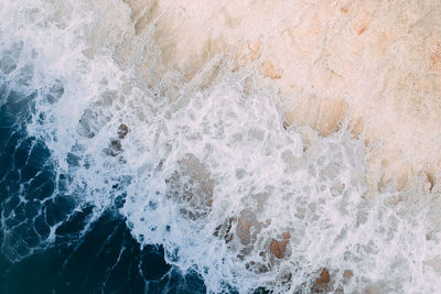 Aerial view of waves splashing on shore