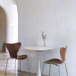 Empty chairs and table against wall at home