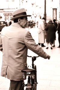 Rear view of man standing on street in city