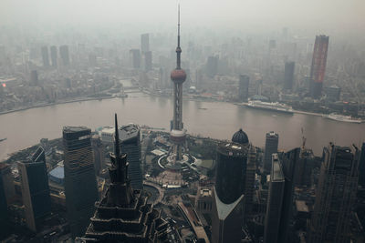 From above of river waterfront district of central shanghai with contemporary towers and buildings in dense smog