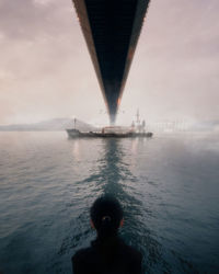 Rear view of woman looking at sea against sky